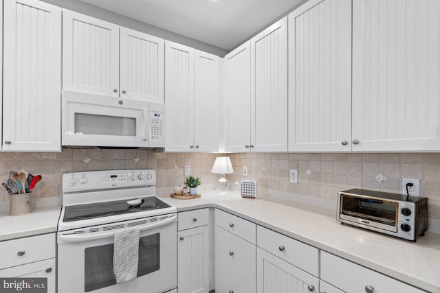 kitchen with tasteful backsplash, white appliances, and white cabinets