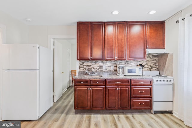 kitchen with white appliances, sink, decorative backsplash, and light wood-type flooring