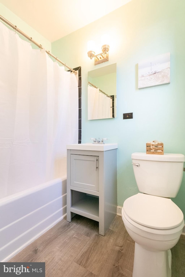 full bathroom with vanity, hardwood / wood-style floors, toilet, and shower / bath combo with shower curtain