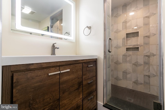 bathroom featuring vanity and a shower with shower door