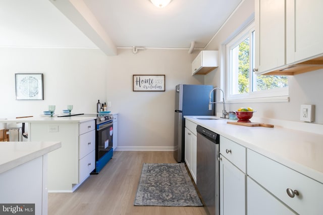 kitchen featuring sink, light wood-type flooring, appliances with stainless steel finishes, beamed ceiling, and white cabinets