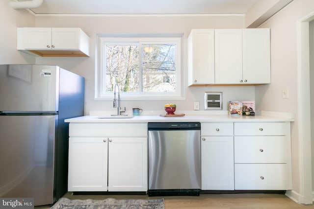 kitchen featuring stainless steel appliances, sink, white cabinets, and light hardwood / wood-style floors