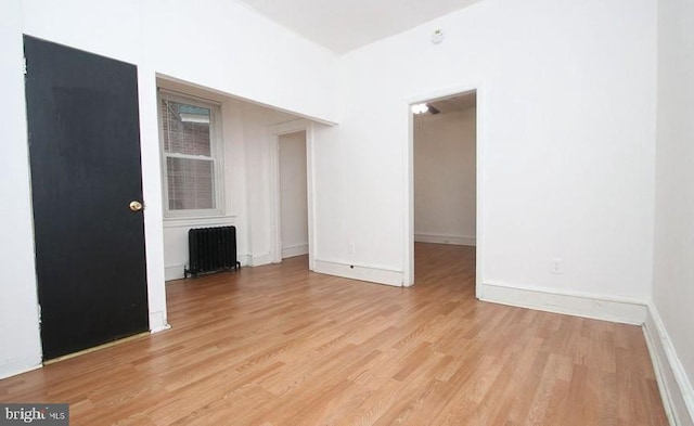 interior space featuring radiator heating unit and light hardwood / wood-style flooring