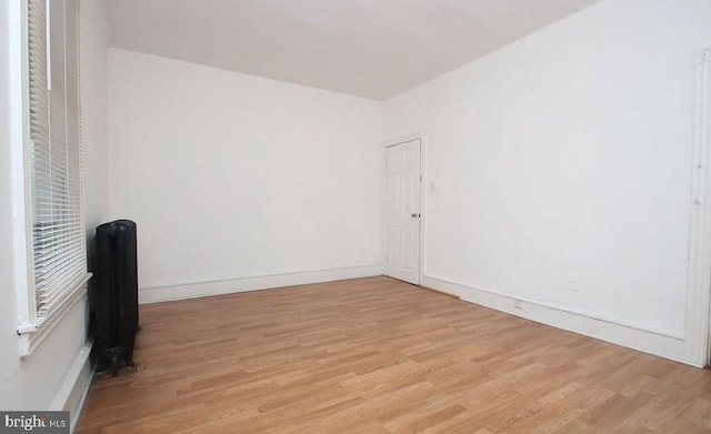 empty room with radiator and light wood-type flooring