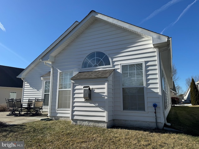 rear view of property with a lawn and a patio