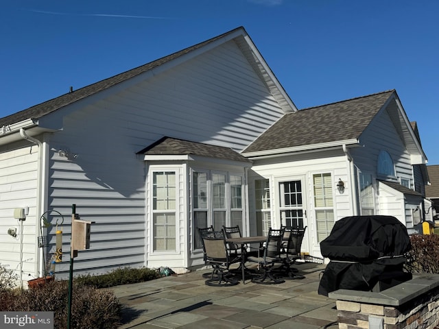 back of house with a patio and a shingled roof