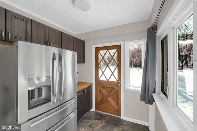 kitchen with wood counters, dark brown cabinets, and stainless steel fridge