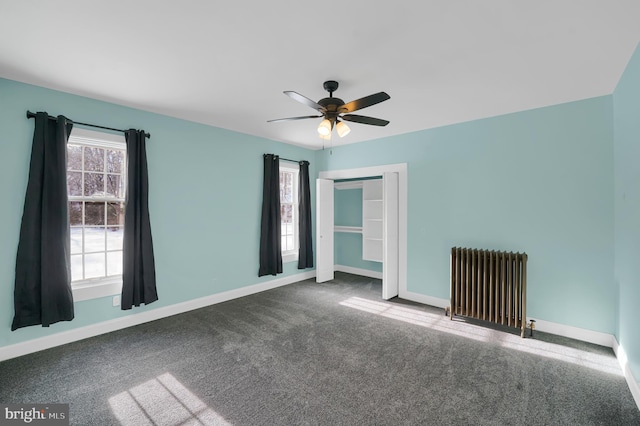 unfurnished room with carpet floors, radiator heating unit, and ceiling fan