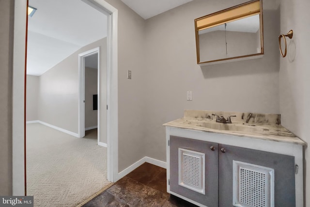 bathroom with lofted ceiling and vanity