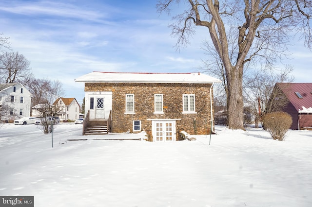 snow covered property with french doors