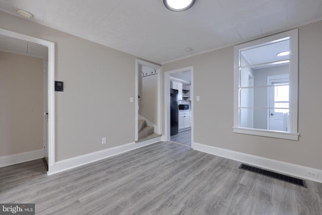 empty room with light hardwood / wood-style flooring