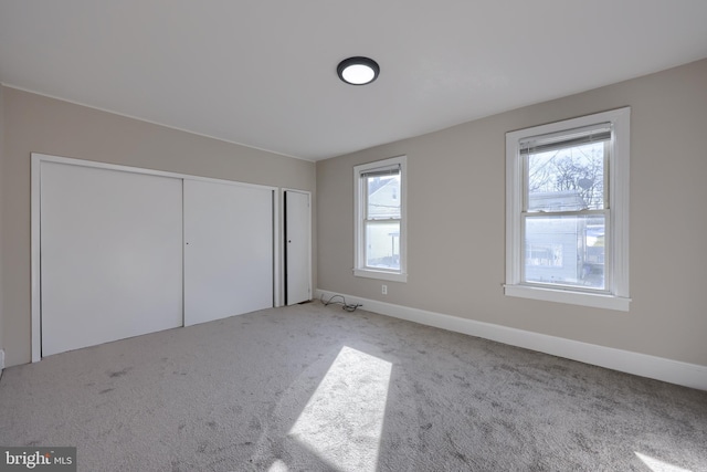 unfurnished bedroom featuring light carpet and a closet