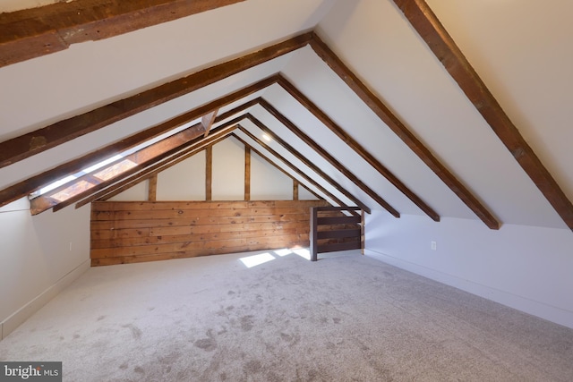 bonus room with vaulted ceiling, carpet, and wood walls