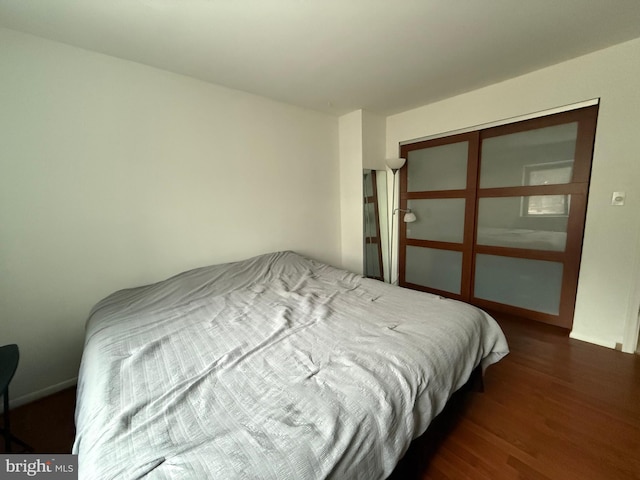 bedroom with dark hardwood / wood-style flooring