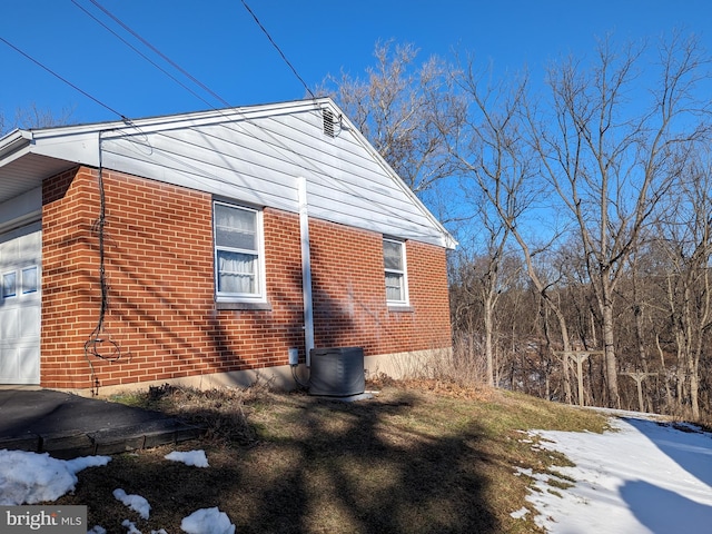 snow covered property with central air condition unit