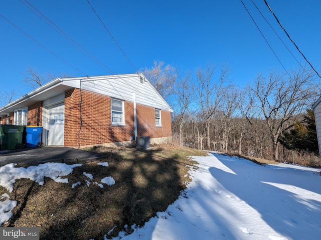 view of snow covered exterior featuring a garage