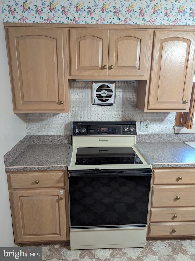 kitchen featuring range with electric cooktop, light brown cabinetry, and tasteful backsplash