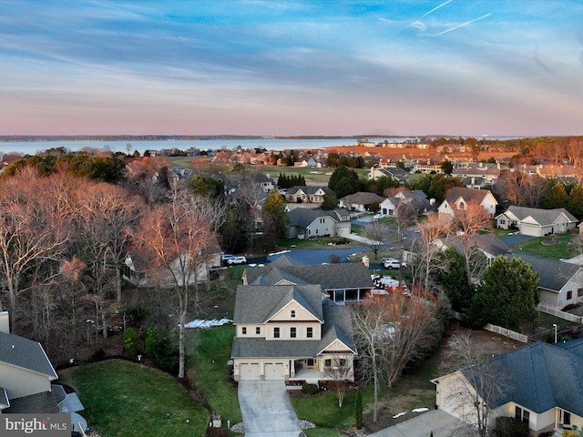 aerial view at dusk featuring a water view