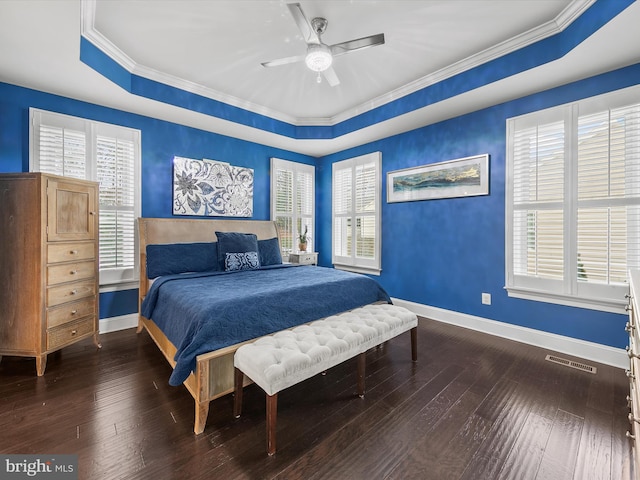 bedroom featuring ceiling fan, ornamental molding, a tray ceiling, and hardwood / wood-style floors