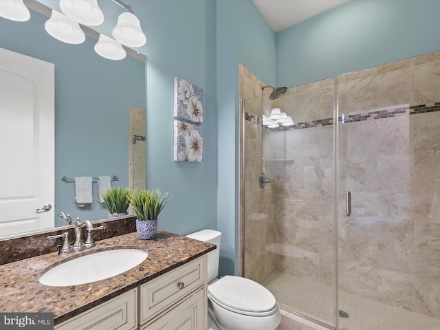 bathroom with vanity, toilet, and a shower with shower door