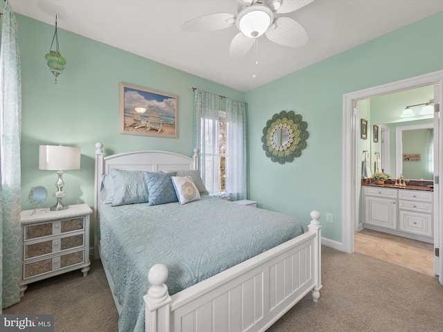 bedroom with ceiling fan, ensuite bathroom, and carpet floors