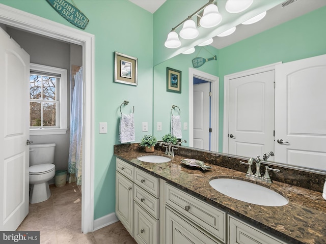 bathroom with vanity, toilet, and tile patterned flooring