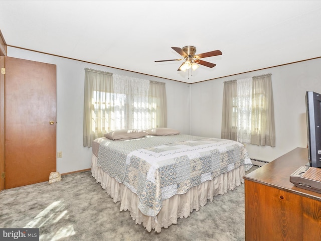 carpeted bedroom featuring a baseboard radiator and a ceiling fan