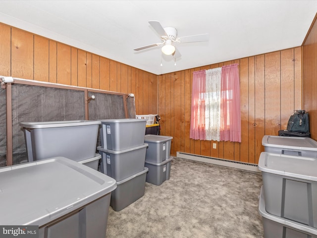 carpeted home office with ceiling fan, wood walls, and baseboard heating