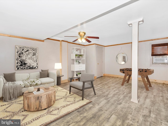 living room with light wood-type flooring, ceiling fan, ornamental molding, and baseboards