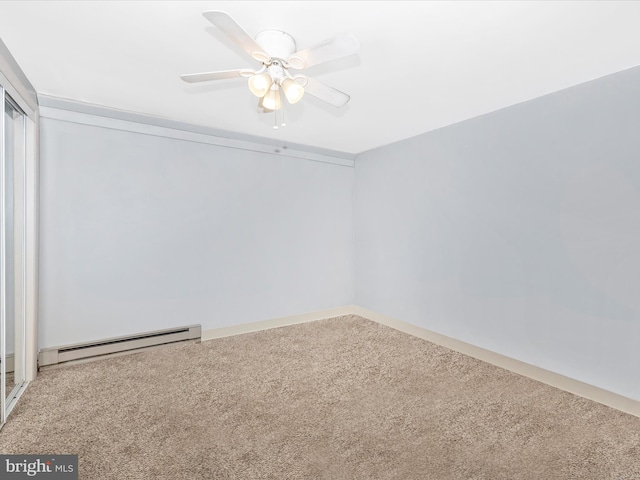 carpeted spare room featuring baseboard heating and a ceiling fan