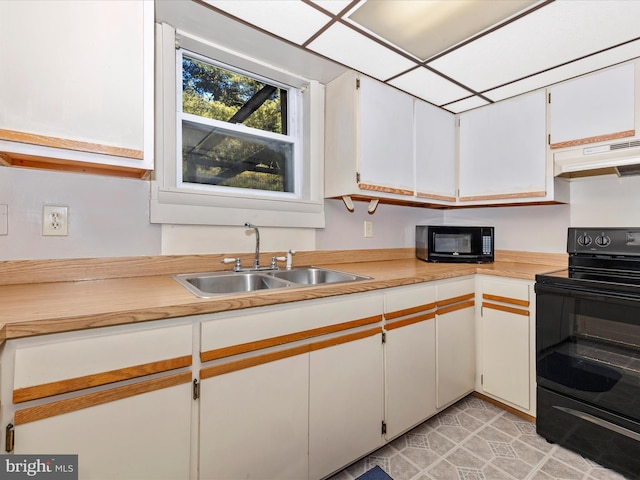 kitchen featuring under cabinet range hood, a sink, white cabinets, light countertops, and black appliances