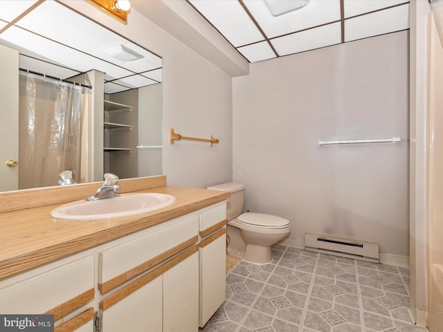 bathroom featuring a paneled ceiling, toilet, a baseboard heating unit, visible vents, and vanity