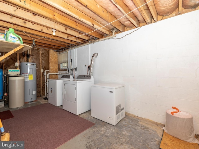 clothes washing area featuring water heater, laundry area, and separate washer and dryer