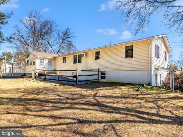 back of house featuring fence, a lawn, and a wall mounted air conditioner