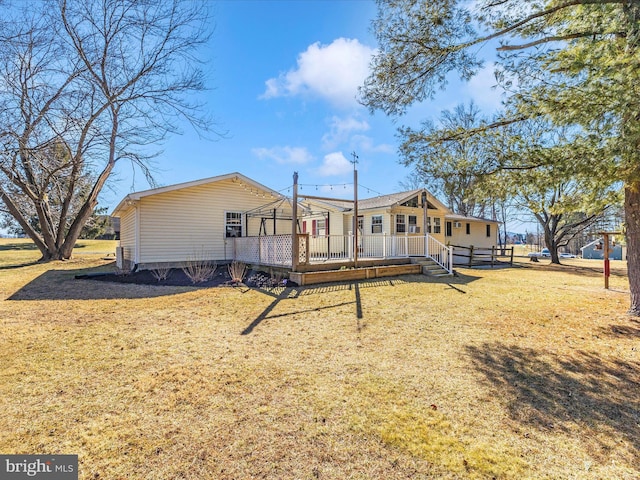 back of property with a deck and a yard