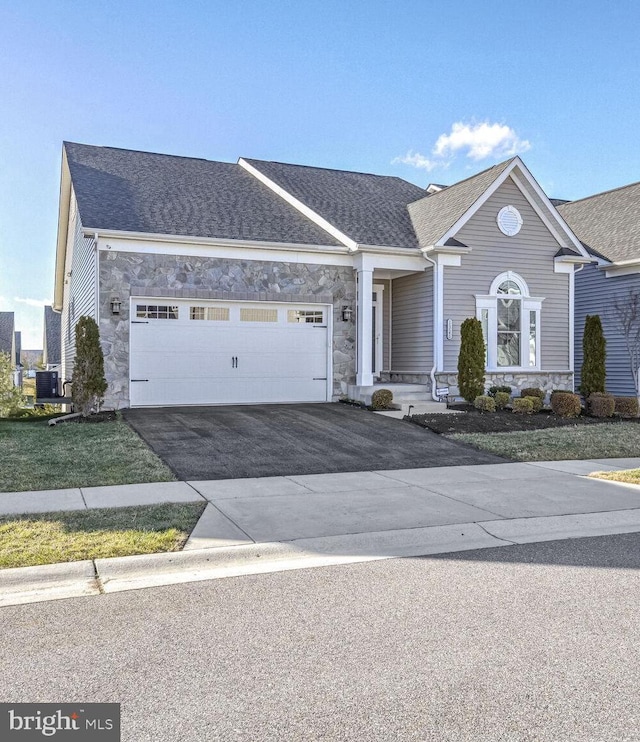 view of front of property featuring a garage and central air condition unit