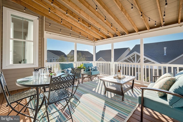 sunroom featuring lofted ceiling with beams, rail lighting, and wood ceiling