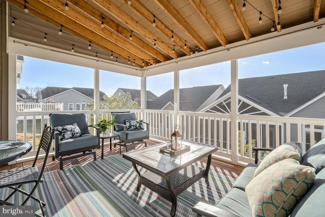 sunroom featuring wood ceiling, beam ceiling, and track lighting