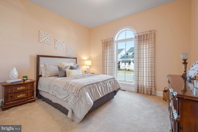 bedroom with light carpet and multiple windows