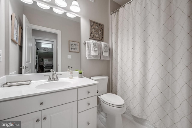 bathroom featuring a shower with curtain, vanity, tile patterned floors, and toilet