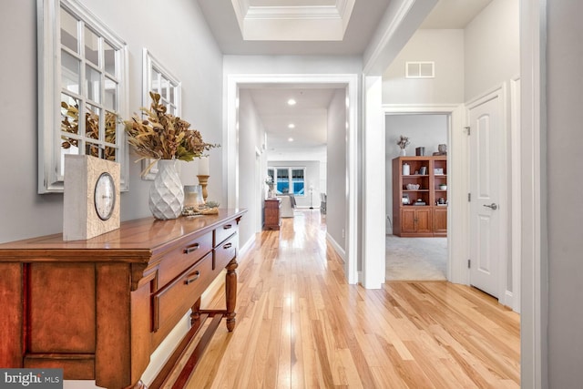 hallway with crown molding and light hardwood / wood-style floors