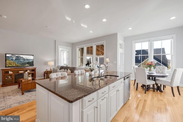 kitchen featuring sink, a kitchen island with sink, dishwasher, light hardwood / wood-style floors, and white cabinets