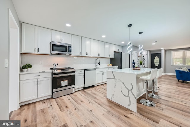 kitchen with stainless steel appliances, sink, and white cabinets