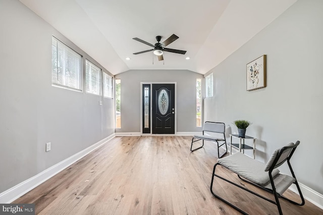 foyer entrance featuring lofted ceiling, a healthy amount of sunlight, and light hardwood / wood-style flooring