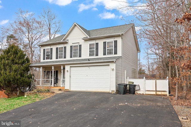 view of front of house featuring a porch, driveway, an attached garage, and fence