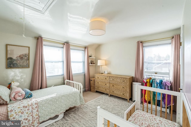 bedroom with multiple windows and light colored carpet