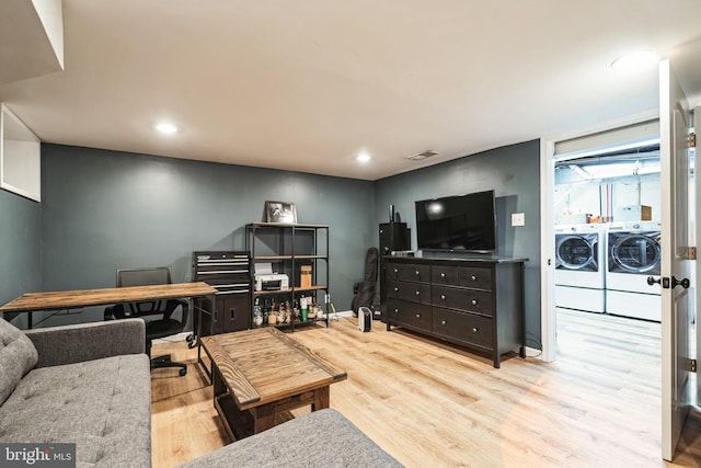 living room featuring separate washer and dryer and light hardwood / wood-style floors