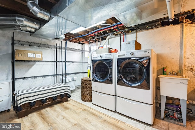 laundry area with hardwood / wood-style flooring and washing machine and dryer