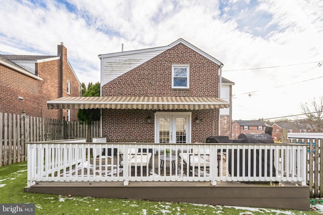 rear view of property featuring a wooden deck and french doors