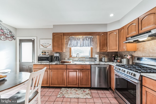 kitchen featuring tasteful backsplash, stainless steel appliances, sink, and light tile patterned floors